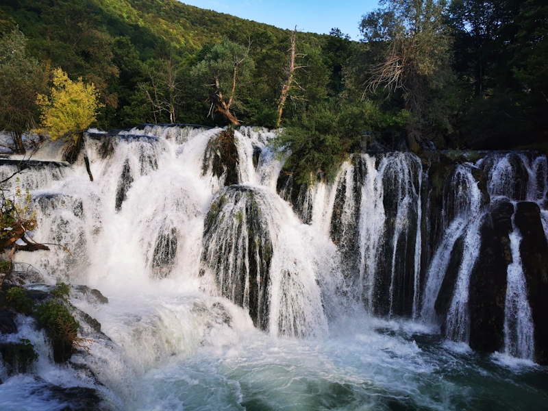 Una‑Wasserfälle in Bosnien mit zwei Adventure‑Bikes am Aussichtspunkt