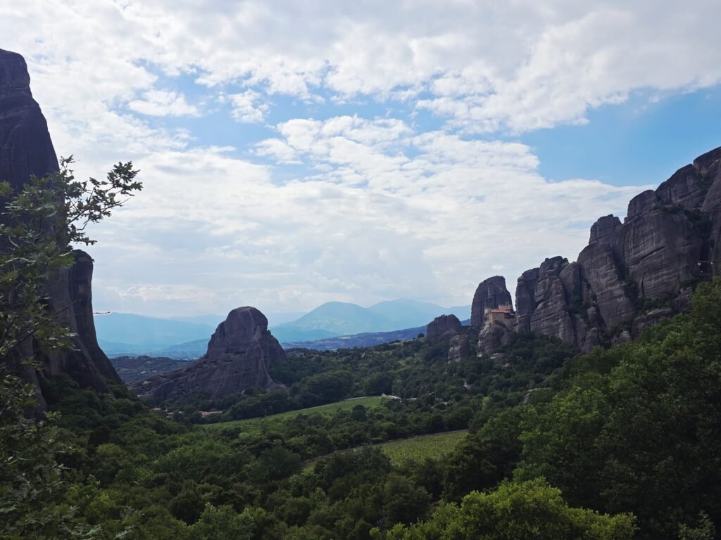 Motorradtour bei Sonnenuntergang entlang der Meteora‑Klöster mit dramatischer Felskulisse.