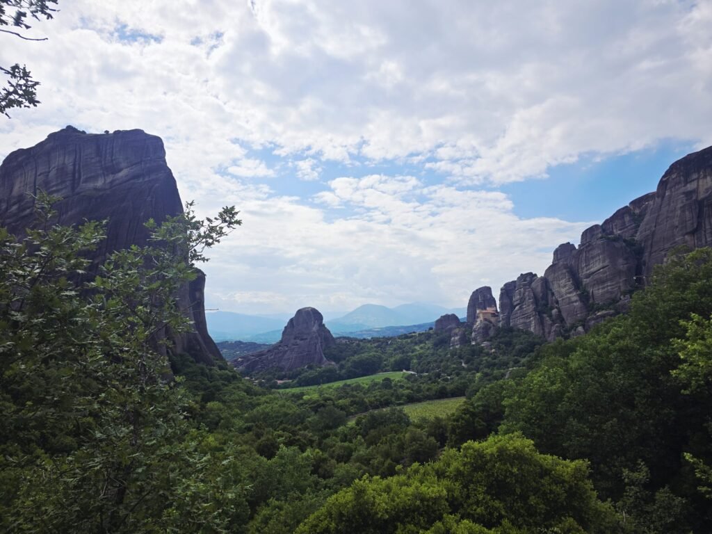 Zwei Motorradfahrer erreichen die Meteora‑Klöster und blicken über die majestätischen Felsenlandschaften Griechenlands.