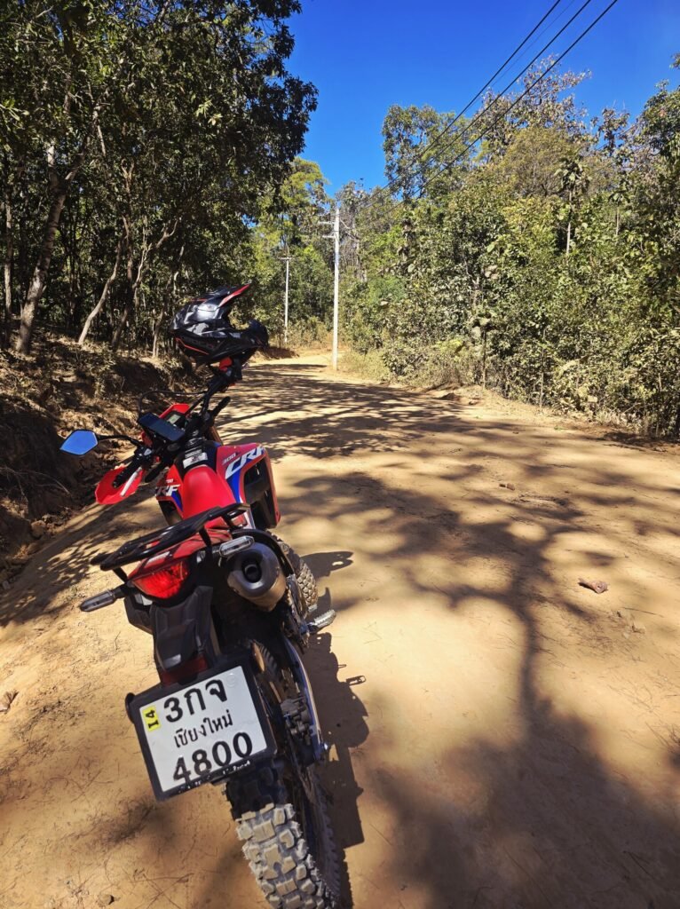 Offroad‑Motorradfahrt bei Pai auf einer staubigen Dschungelpiste im Norden Thailands