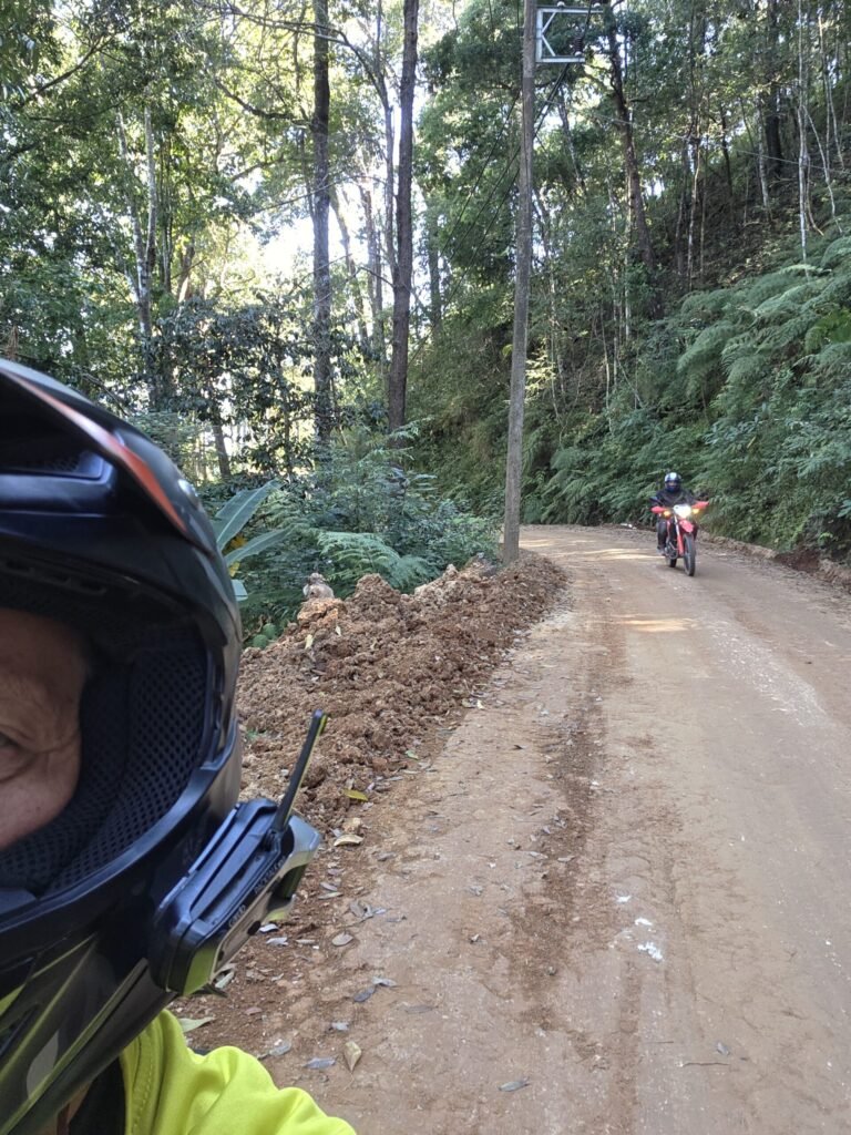 Motorradfahrerin meistert eine schlammige Offroad‑Passage bei Pai während einer Thailand‑Motorradtour