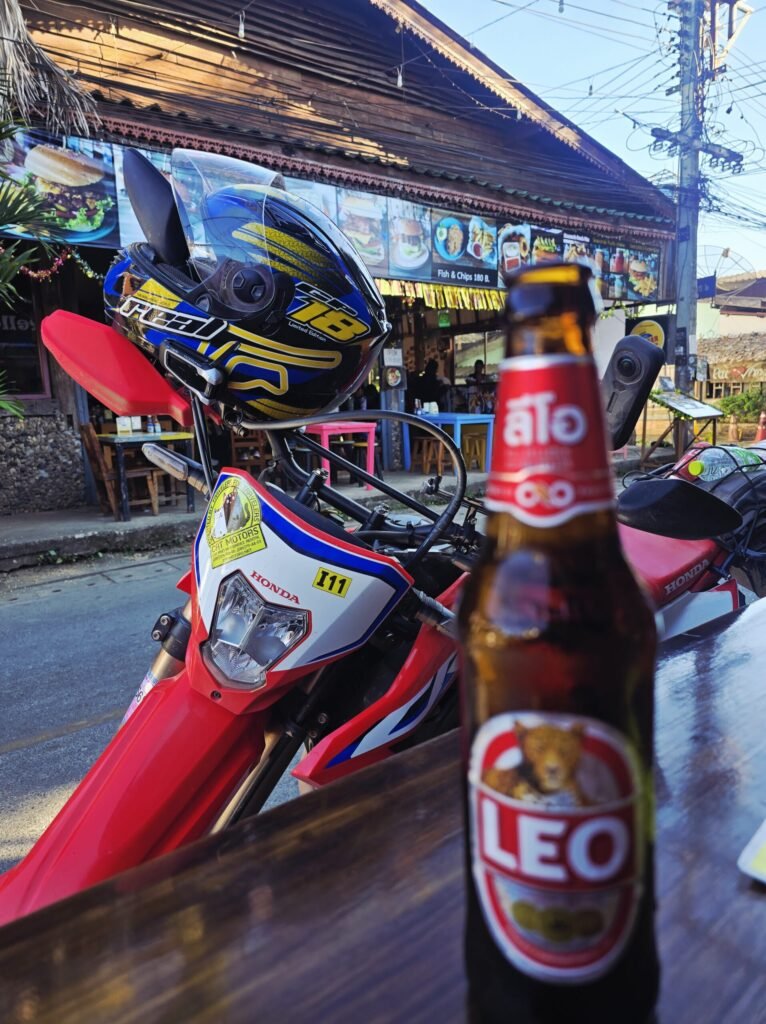 Reisende prüft ihr Motorrad nach einer anspruchsvollen Offroad‑Etappe bei Pai