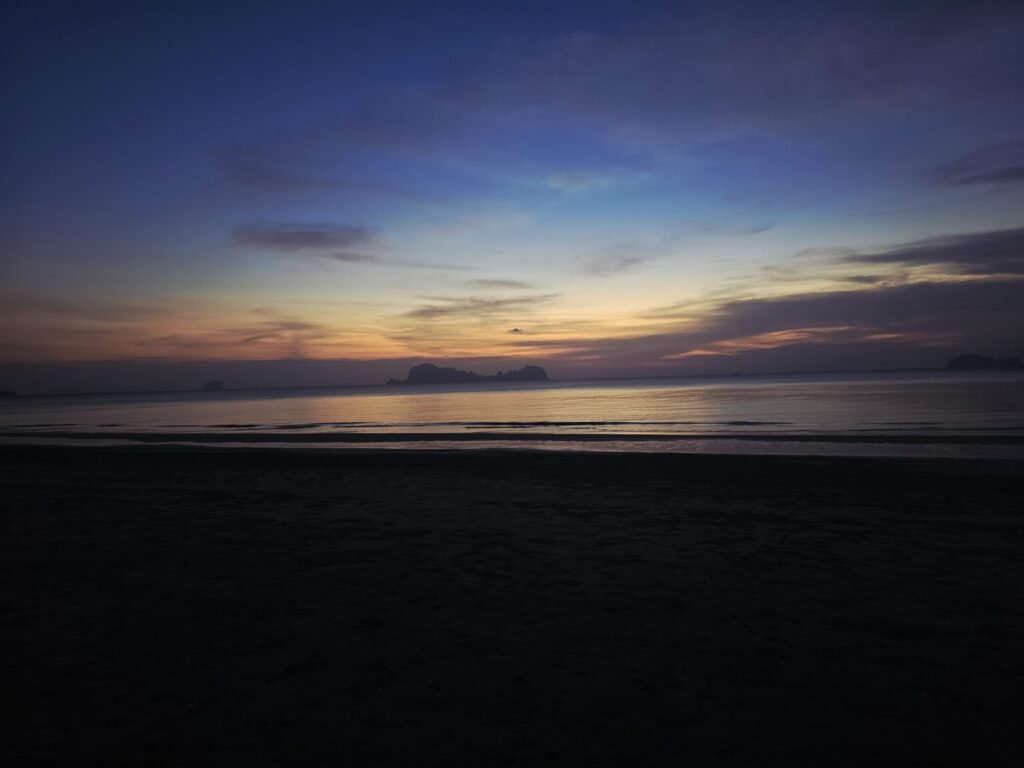 Blick über die ruhige Landschaft von Koh Sukorn mit Hügeln im Hintergrund