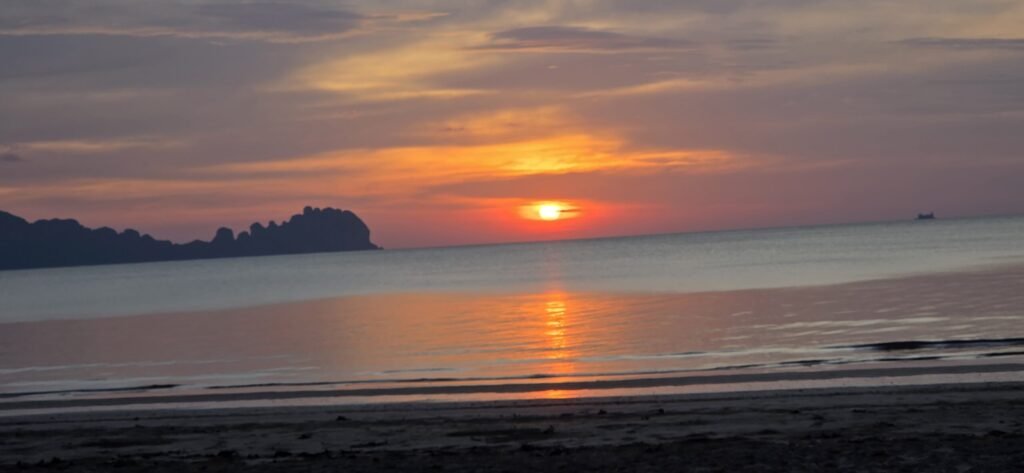 raditionelles Dorfhaus auf Koh Sukorn mit Palmen im Hintergrund